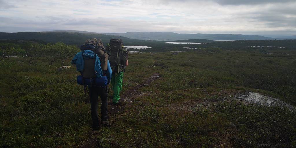 To menn som går på vidda med tunge ryggsekk.