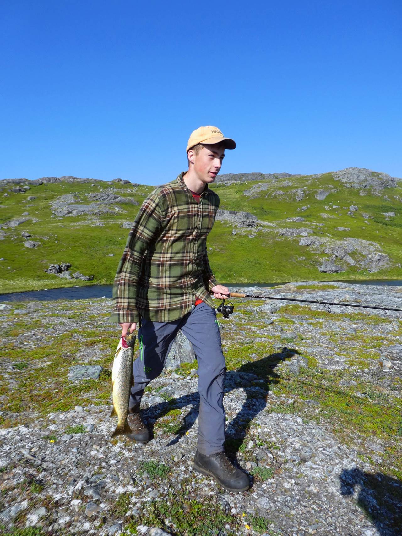 Fisker som går med stor ørret i handa