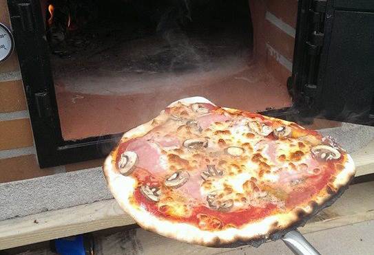 Pizza stekt i vedfyrt pizzaovn